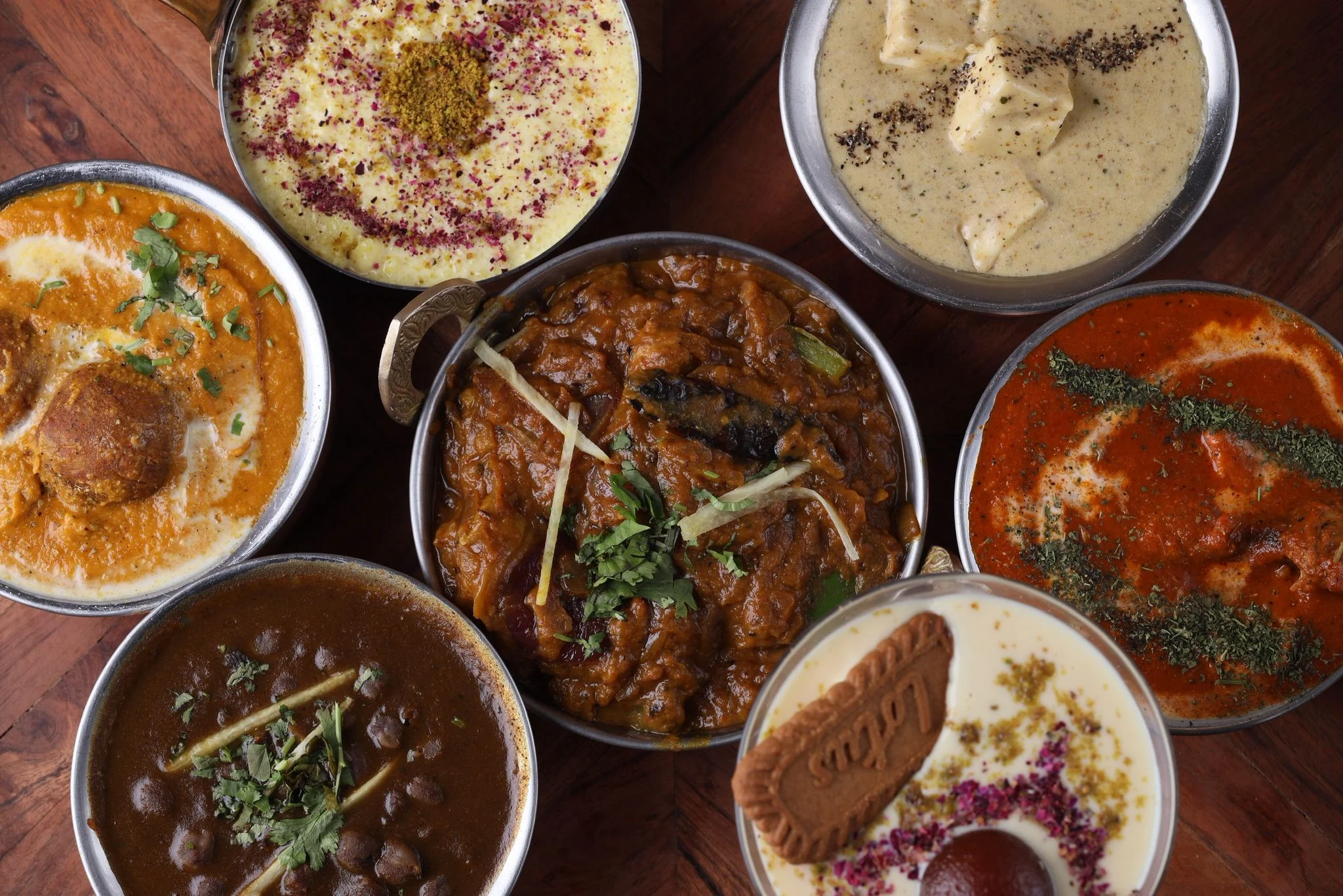 Assorted creamy curries with herb garnishes in bowls
